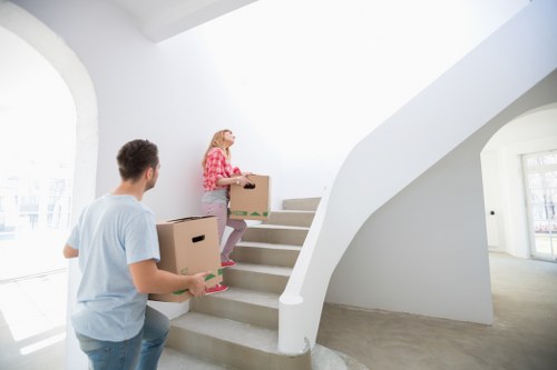 Movers carrying furniture through a flat entrance in Paddington